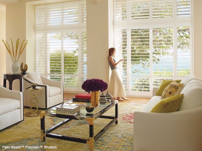 A living room with green accents. Shown with Palm Beach Polysatin Shutters; available at Beverly Hills Window Treatments in Naples